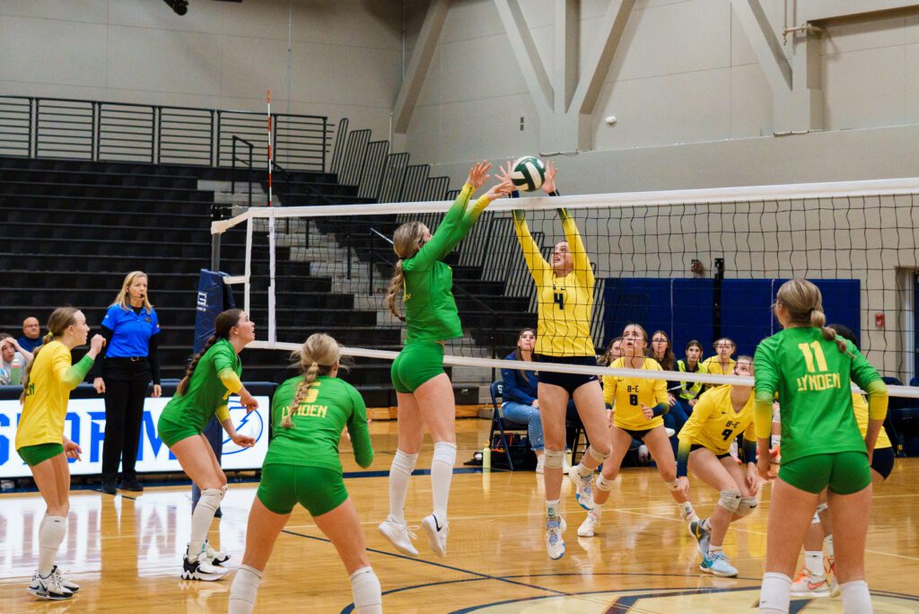 Lynden's Finley Parcher leaps in the air to block the shot as other players and attendees watch to see the results.