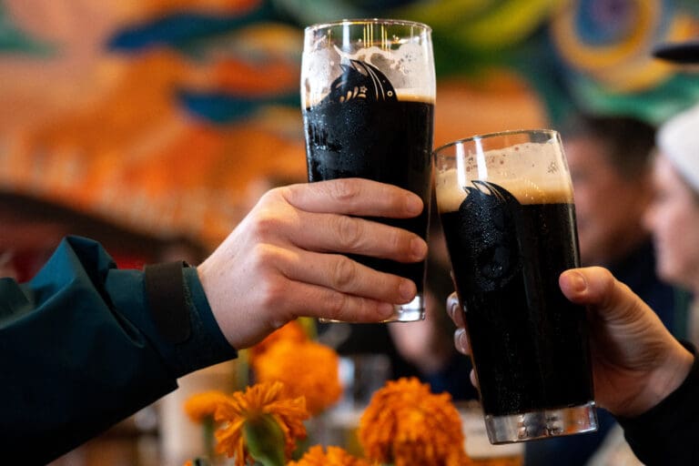Two patrons clink glasses during a Día de Muertos event on Nov. 4 hosted by El Sueñito Brewing Company. The Sunnyland neighborhood brewery opened in February.