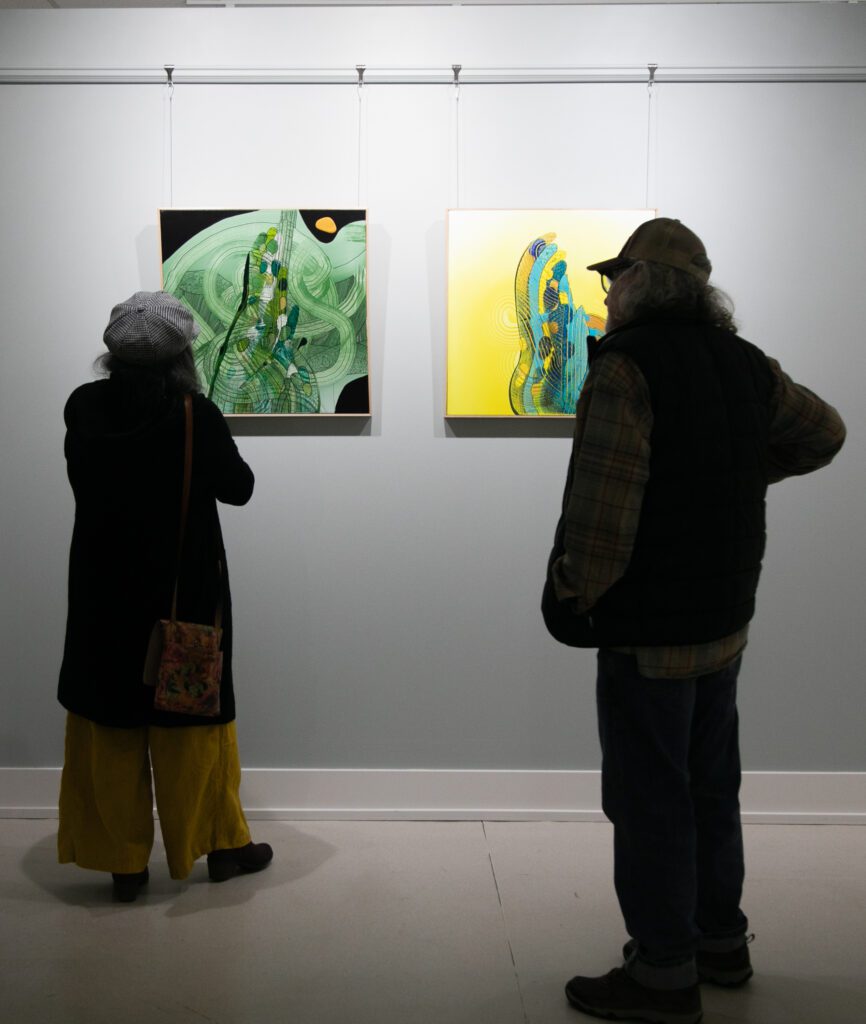 "Nooksack Bloom," left, and "Desert Bloom" are being viewed by two attendees.