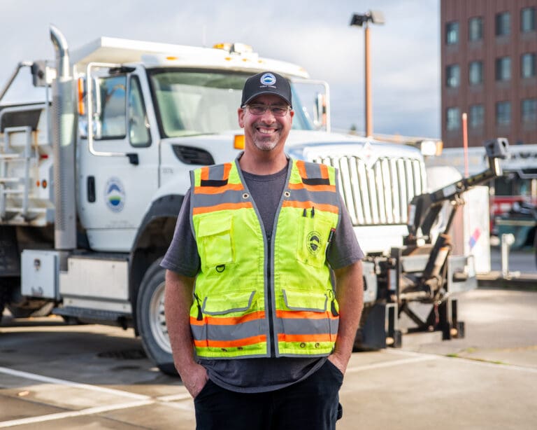 Scott Van Diest stands in front of a City of Bellingham dump truck in the public works yard on Pacific Street. Van Diest said his attention to detail and strong work ethic help him succeed in his role.