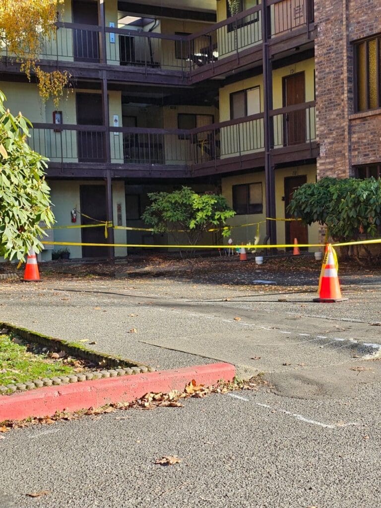 Cones and caution tape surround a sewage spill at Old Mill Village apartments.