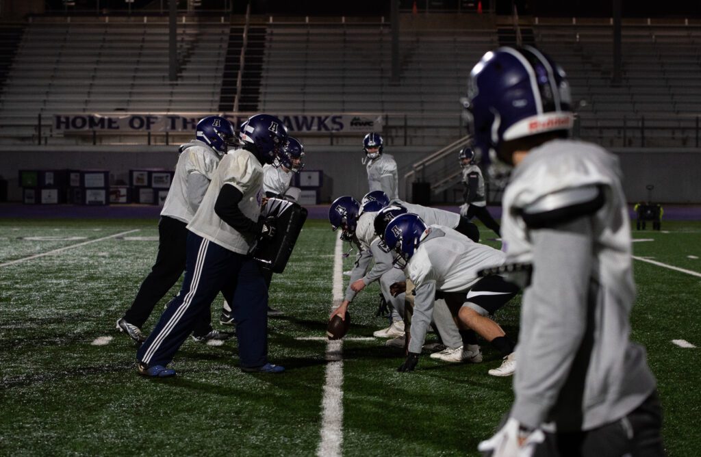 Anacortes' offense lines up against the scout team defense who are holding cushions for practice.