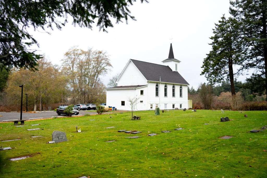 The Lummi Island Congregational Church is surrounded by trees and the island cemetery on Lummi Island. The United Church of Christ building was finished in 1903. Pastor Jamie Kepros upholds the tradition of the church being a community space for all islanders.