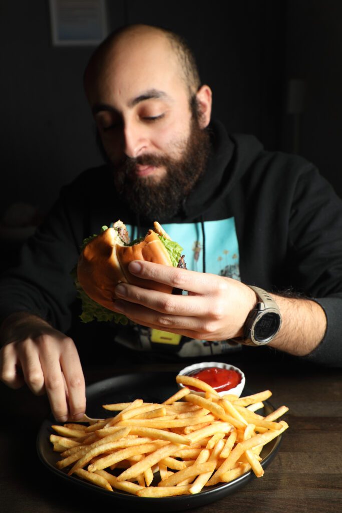 Mark Saleeb digs into a fresh cheeseburger and fries.