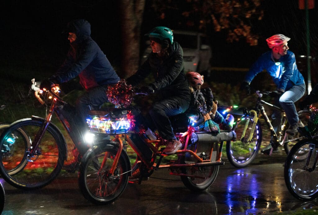Cyclists begin their journey back to Depot Market Square in their brightly lit bicycles wearing rainproof clothing and bike helmets.