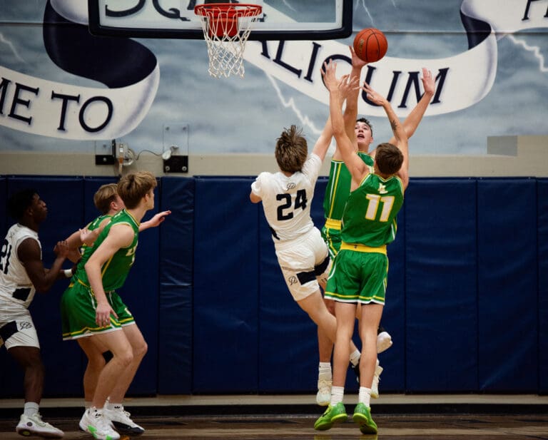 Lynden senior Ty Holleman (11) and junior forward Brant Heppner swat Squalicum sophomore Cole Burke's shot as other players rush over to help.