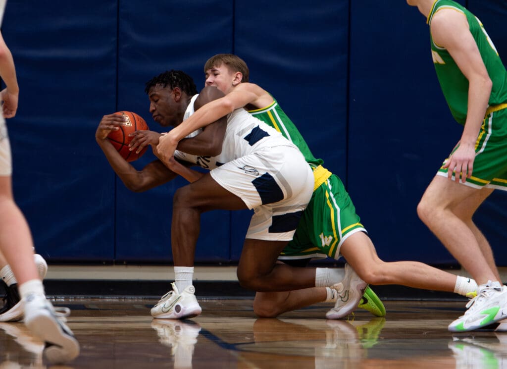 Lynden 's Ty Holleman grabs onto Squalicum's Marcus Nixon while fighting for a loose ball.
