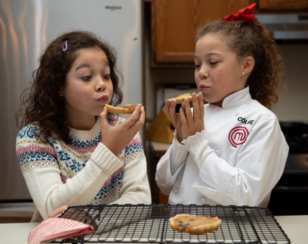 Sisters Heidi, left, and Colbie Buck, wearing her masterchef coat, blow on the hot Canadian butter tarts fresh from the oven.