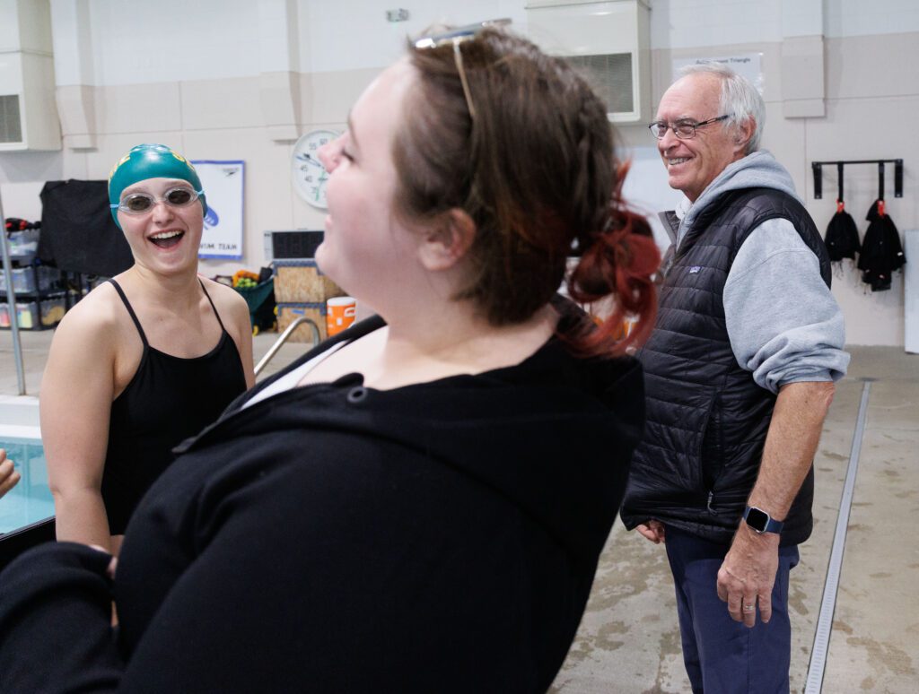 Sehome swim coach Don Helling gets a laugh from his swimmer and assistant coach Lauren Heath.