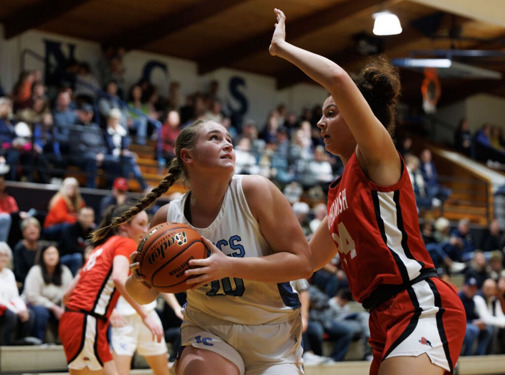 Lynden Christian’s Tabby DeJong drives for a basket as Snohomish defends.