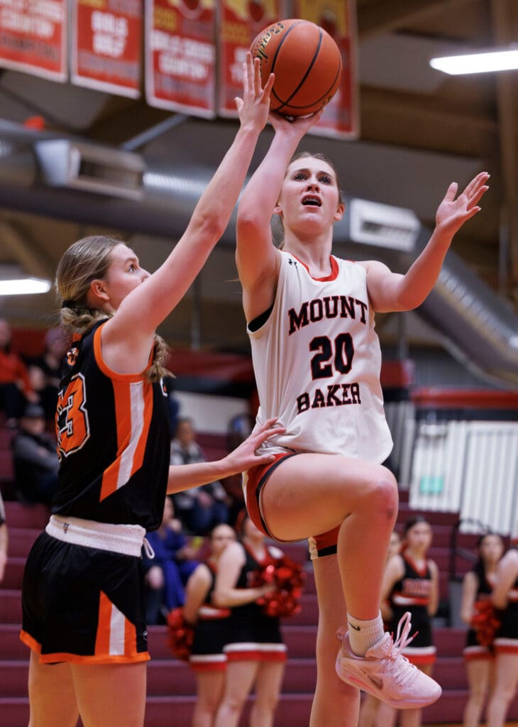 Mount Baker’s Violet Fox leaps for a contested shot while an opposing member reaches to stop her.