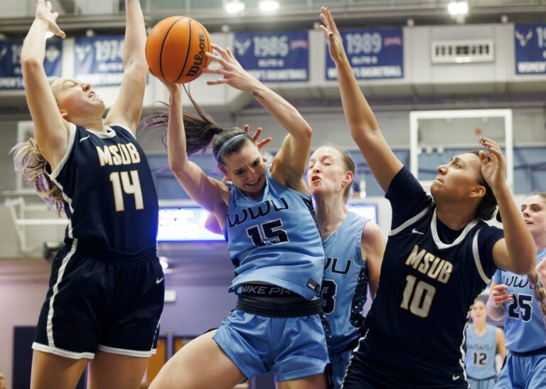 Western Washington University's Brooke Walling haul in a rebound as she accidentally hits her teammate behind her while surrounded by the opposing team.