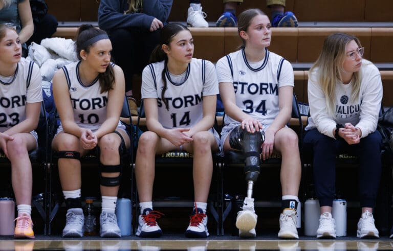 Squalicum girls basketball freshman sit on the sidelines as they stay focused on the game.