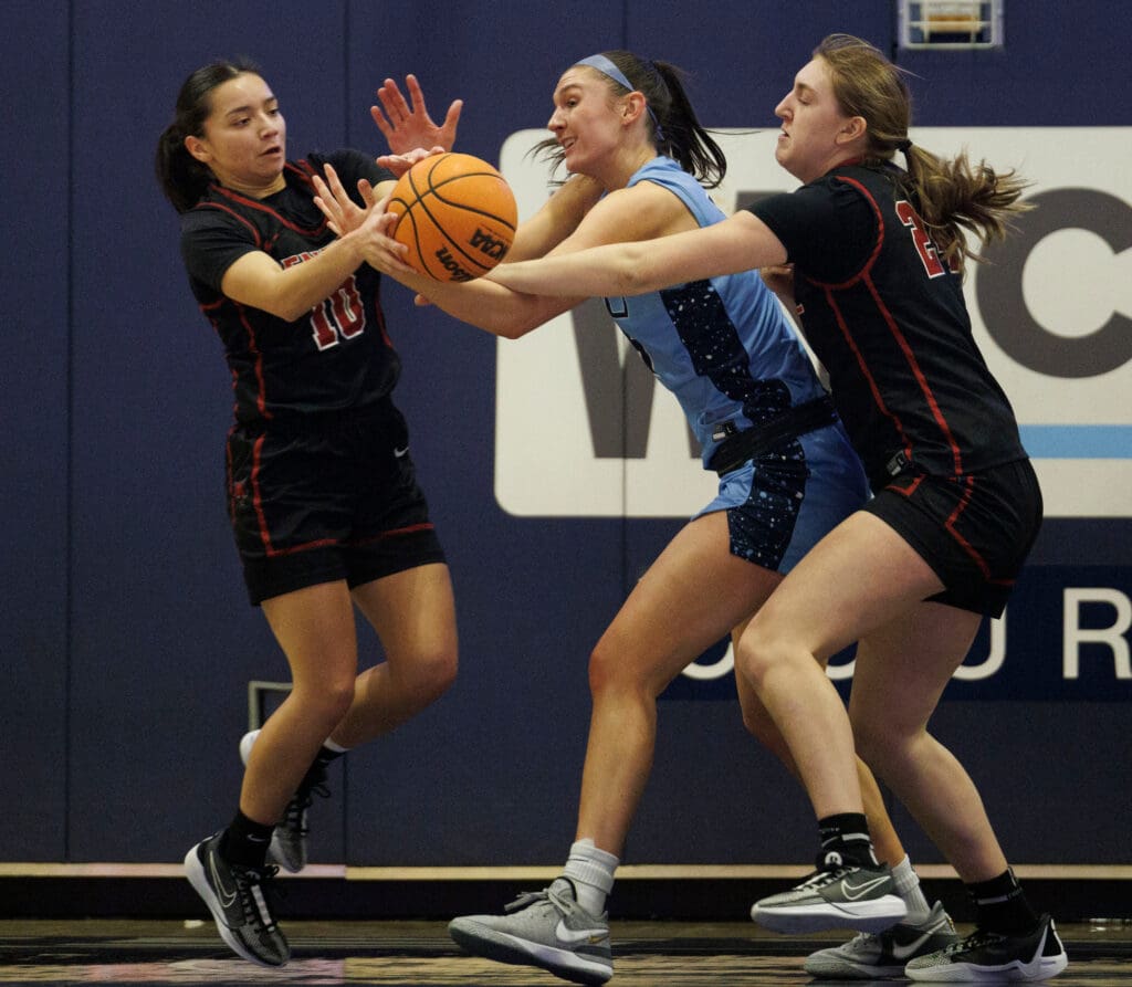 Western Washington University's Brooke Walling fights for the ball as all three players reach for the ball.