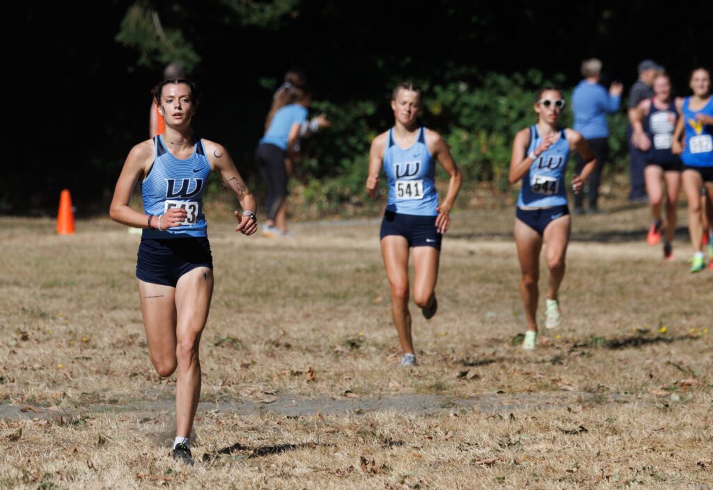 Western Washington University’s Ashley Reeck, left, heads to the finish line ahead of teammates with all three dressed in their team's signature blue color.