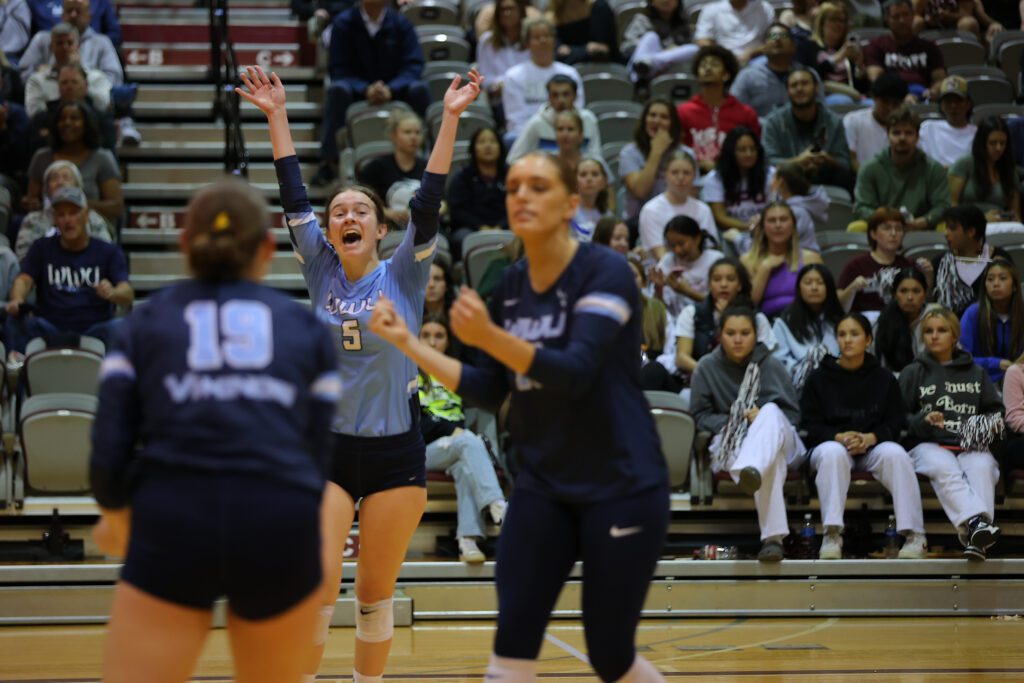 Western Washington University's Finnley Claeys (5) celebrates with her hands in the air as spectators watch from the bleachers.