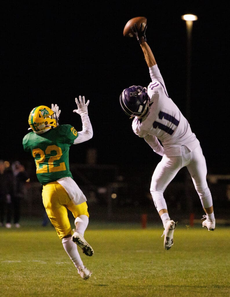 Anacortes’ Cooper Barton breaks up a pass as he leaps into the air to intercept the ball.