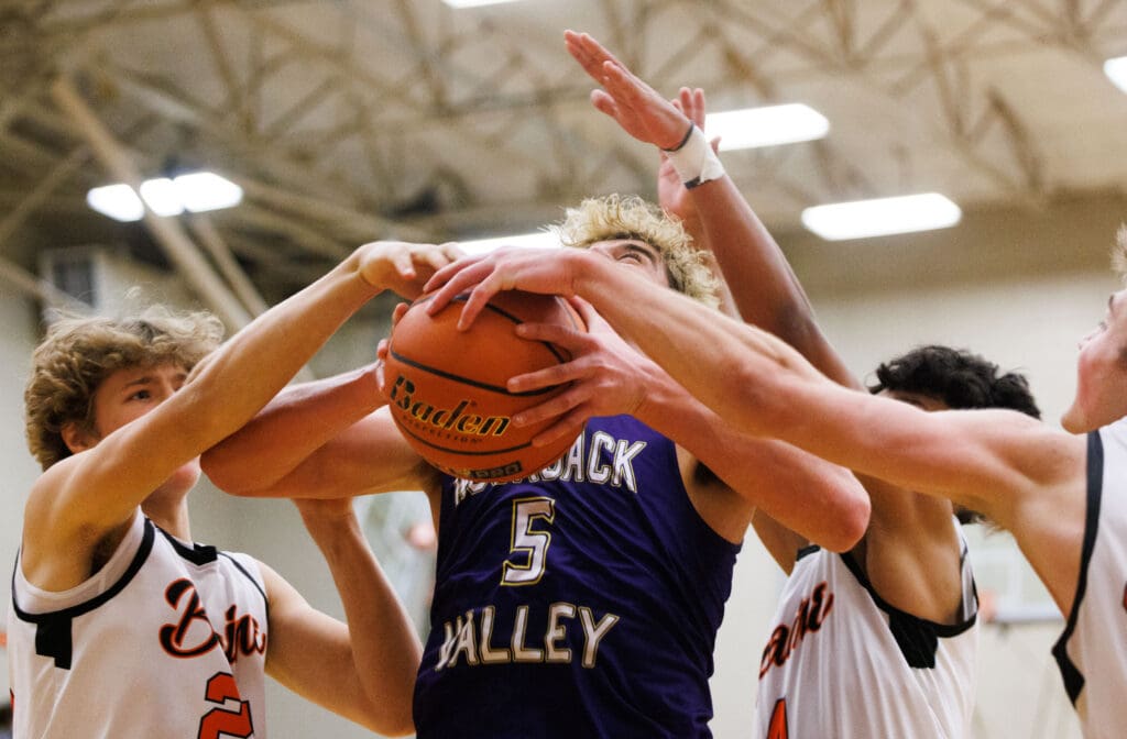 Nooksack Valley's Colton Lentz tries to bring the ball up as multiple defenders reach over for control of the ball.