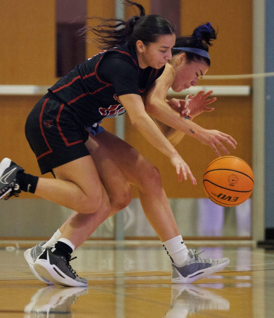 Western Washington University's Stephanie Peterson battles for a loose ball as she bumps into a Central Washington University player.
