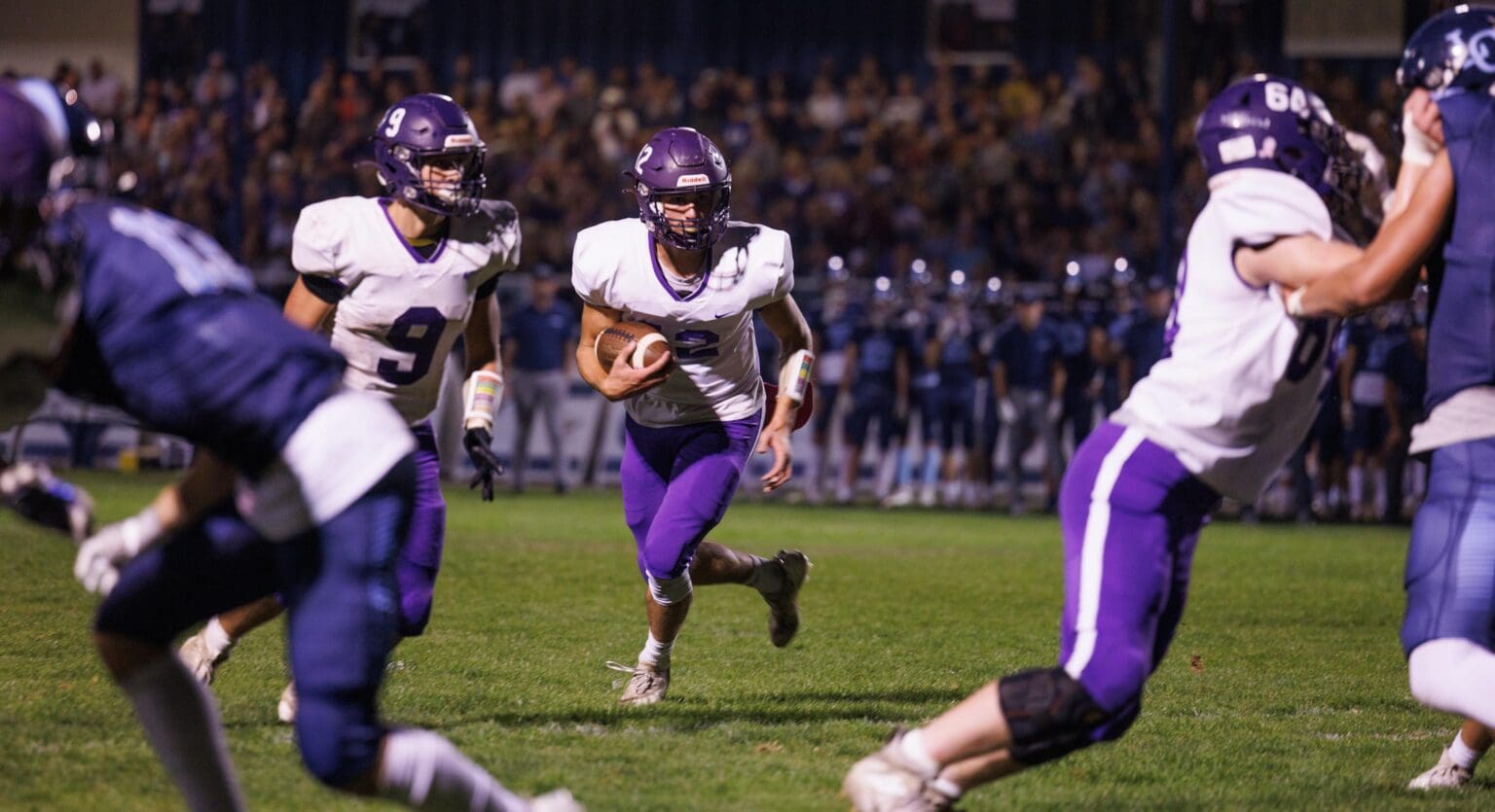 Nooksack Valley quarterback Joey Brown looks for an opening as his teammates try to defend him.
