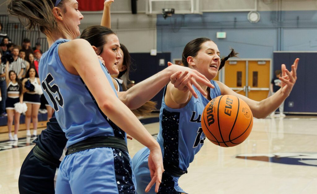 Western Washington University's Demi Dykstra is fouled as she dives to the basket against the opposing teaam but her hands become entanged with others.