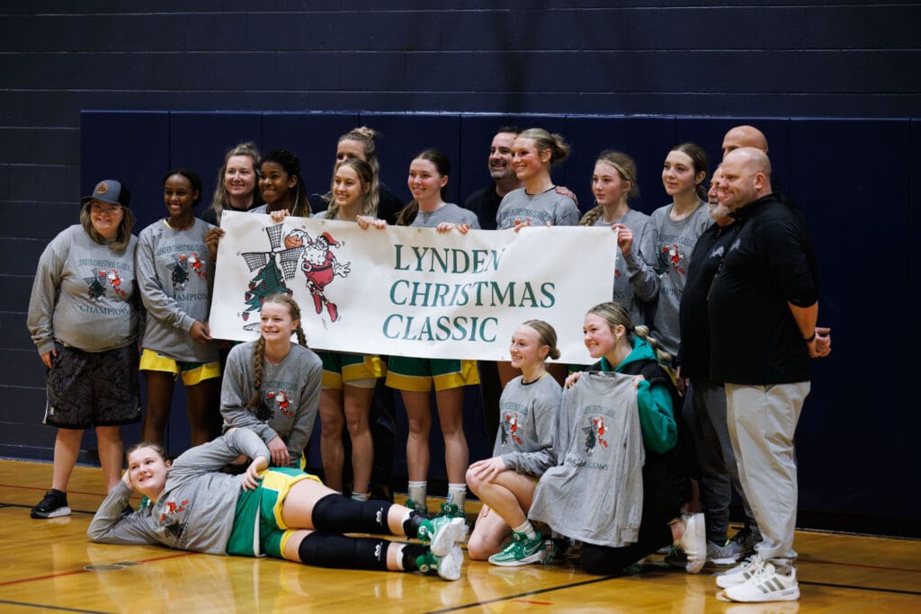 Players pose with championship T-shirts and a banner after winning the Lynden Christmas Classic.