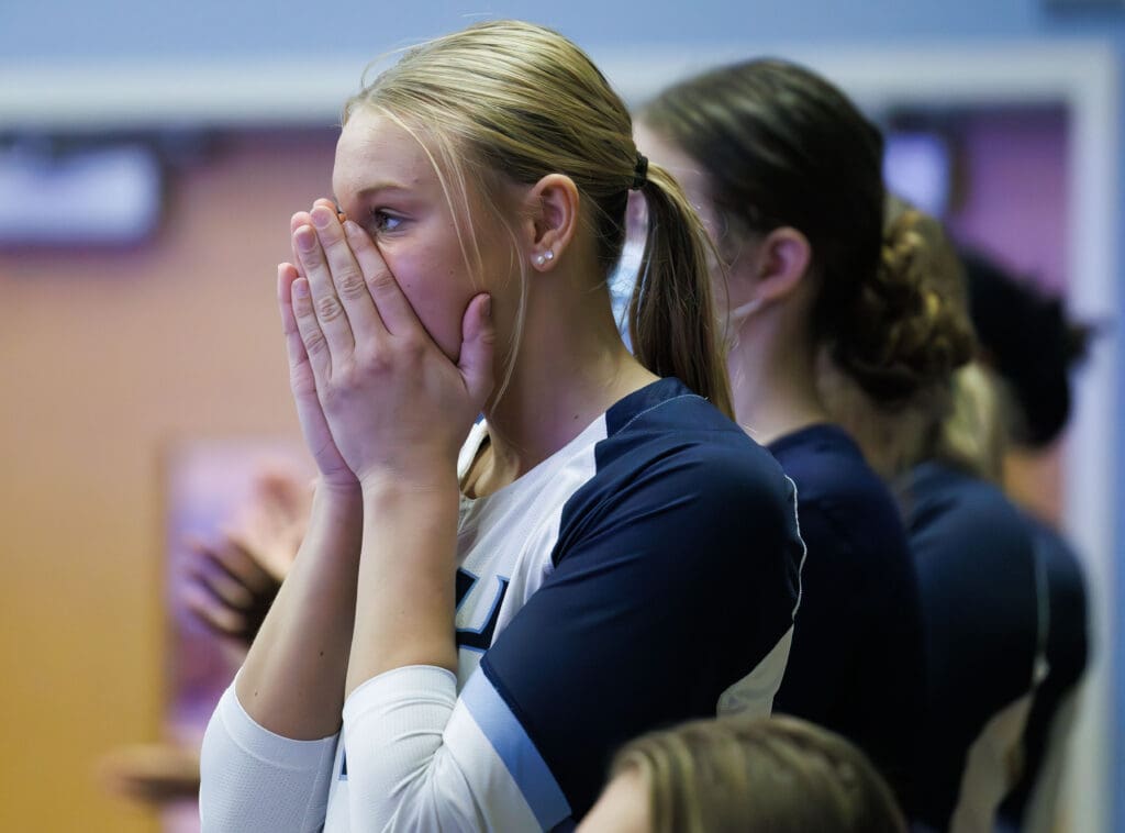 Western Washington University's Anna VanderYacht reacts by clasping her hands to her face in shock as others near her clap.