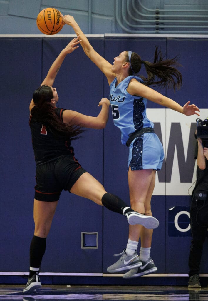 Western Washington University's Brooke Walling tries to block a shot by a Central Washington University player as she manages to take the shot over her.
