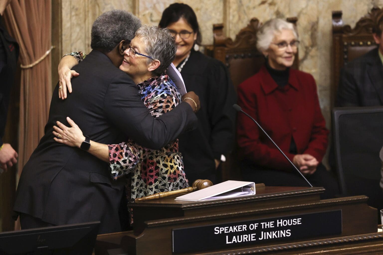 Speaker of the House Laurie Jinkins hugs Pastor Gregory Christopher from the Shiloh Baptist Church in Tacoma on the first day of the legislative session at the Washington state Capitol in Olympia
