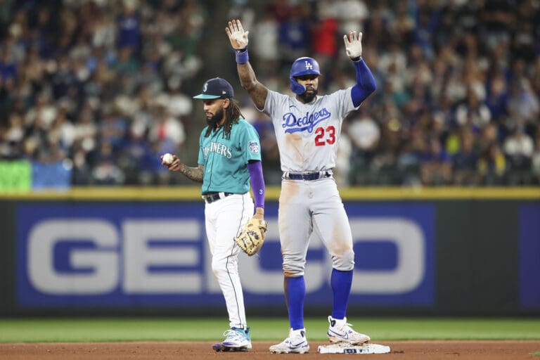 Los Angeles Dodgers' Jason Heyward celebrates after hitting a double as Seattle Mariners shortstop J.P. Crawford reacts during the seventh inning of a baseball game Saturday
