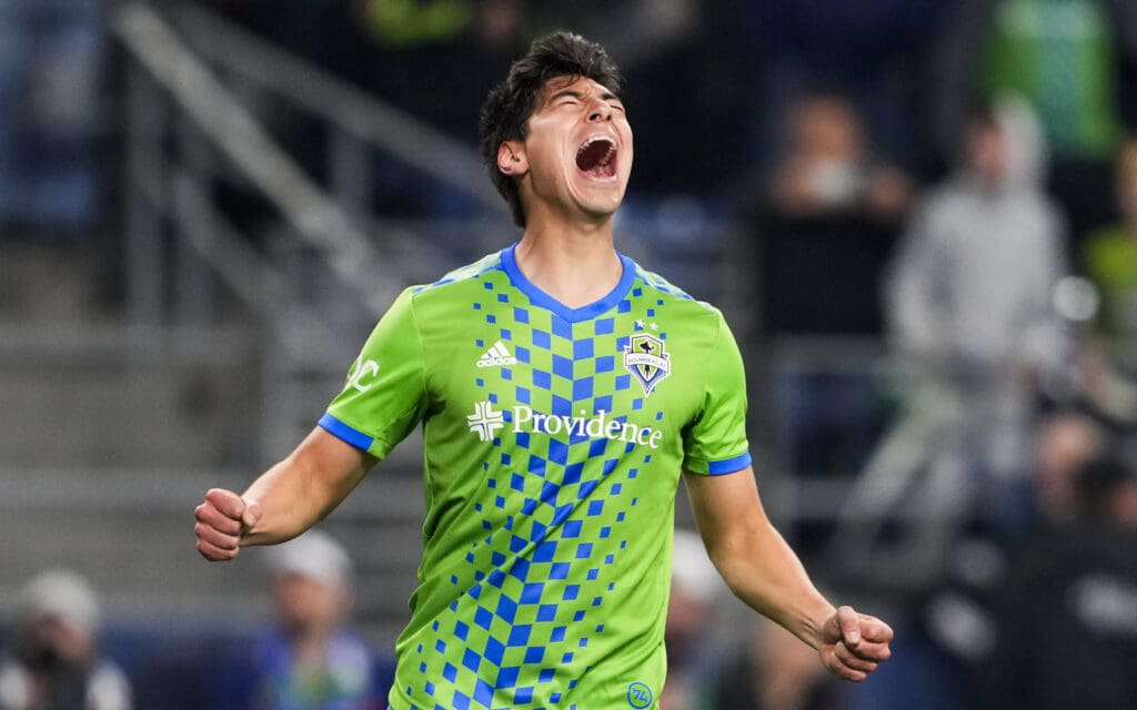 Seattle Sounders midfielder Josh Atencio reacts by screaming with his hands clenched in a fist.