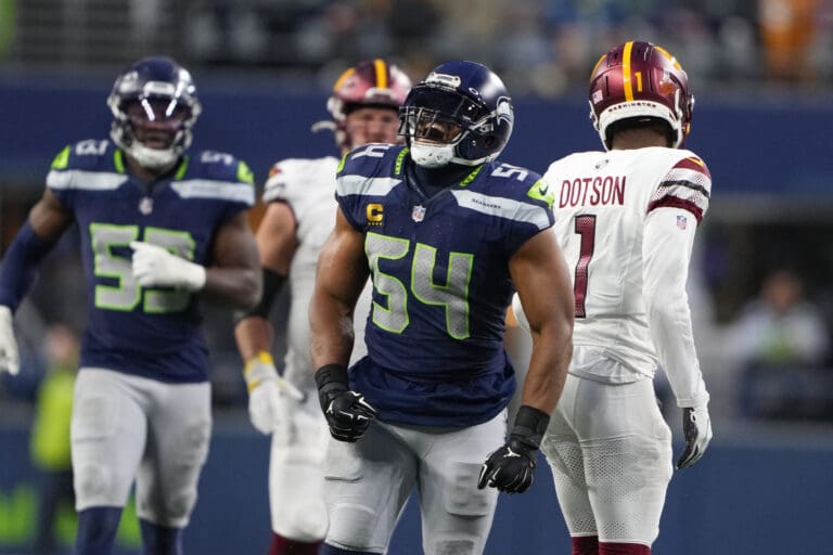 Seattle Seahawks linebacker Bobby Wagner (54) reacts as he is surrounded by a mix of his teammates and the opposing team players.