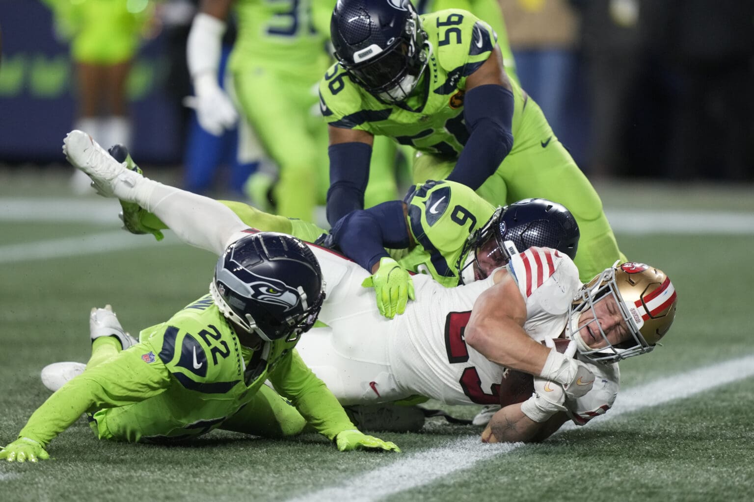 San Francisco 49ers running back Christian McCaffrey (23) falls into the endzone for a touchdown as other players fall with him.