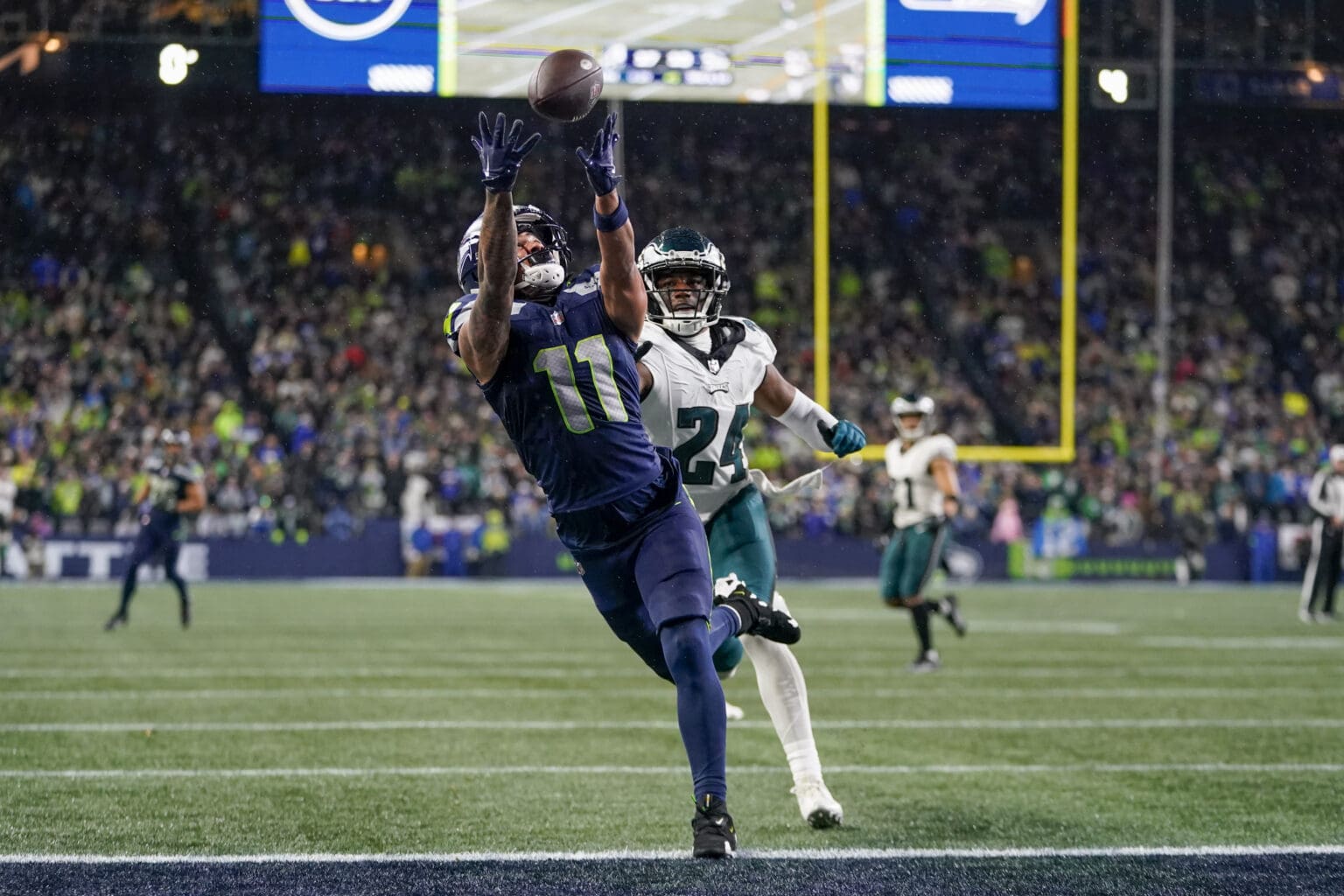 Seattle Seahawks wide receiver Jaxon Smith-Njigba (11) makes a touchdown catch in front of Philadelphia Eagles cornerback James Bradberry (24) as he reaches out to try and prevent him from catching it as other players watch on from behind them.