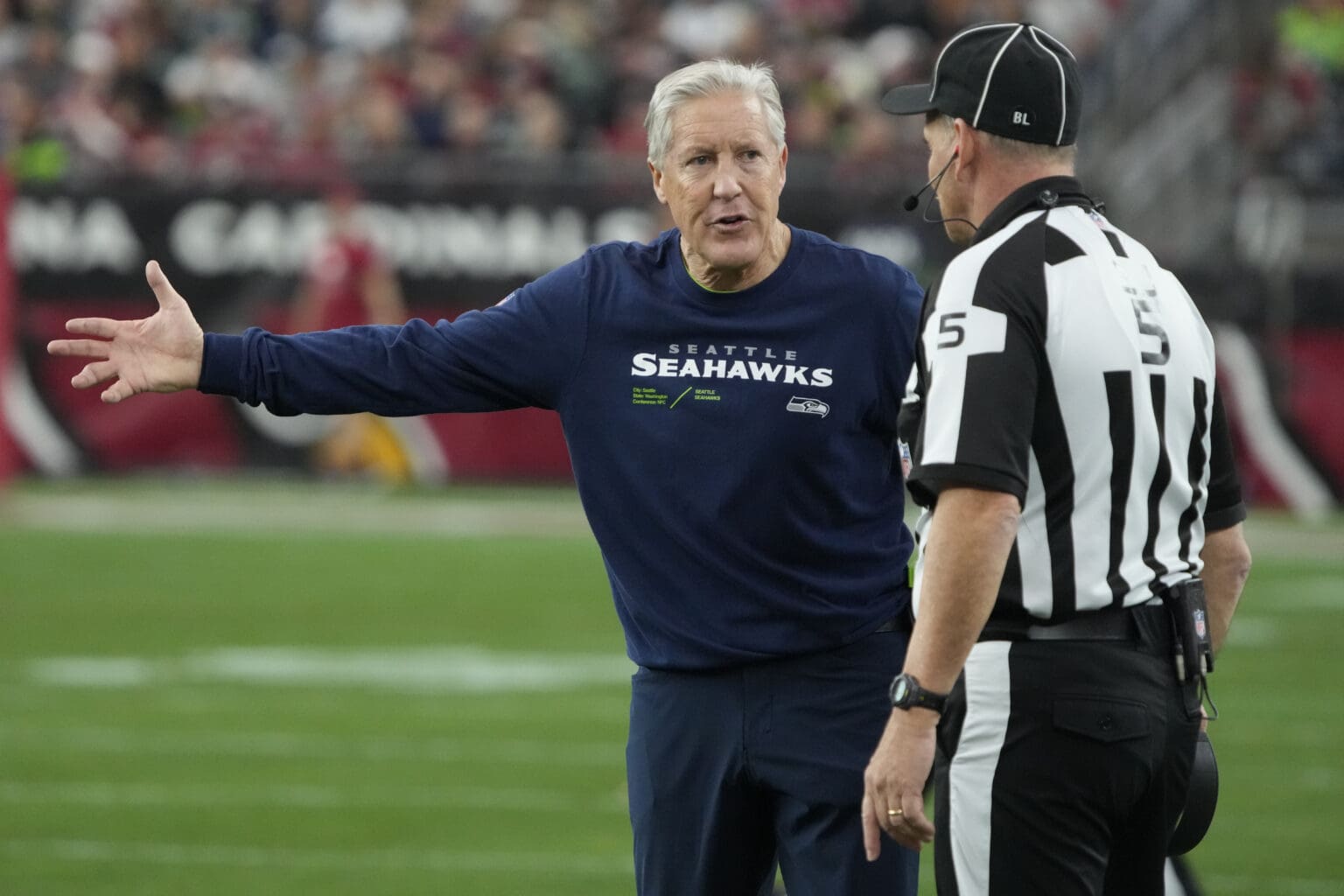 Seattle Seahawks head coach Pete Carroll argues a call with side judge Jim Quirk (5) as he gestures with one hand towards the field.
