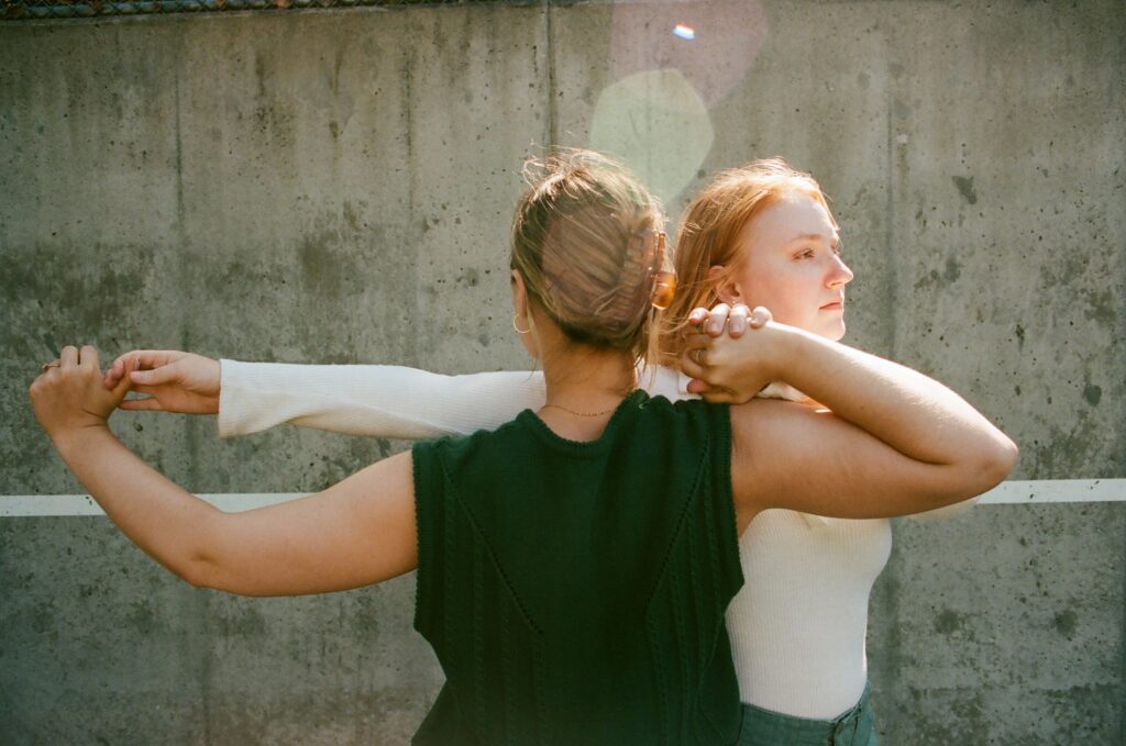 Two women have their hands interlocked during a dance routine.