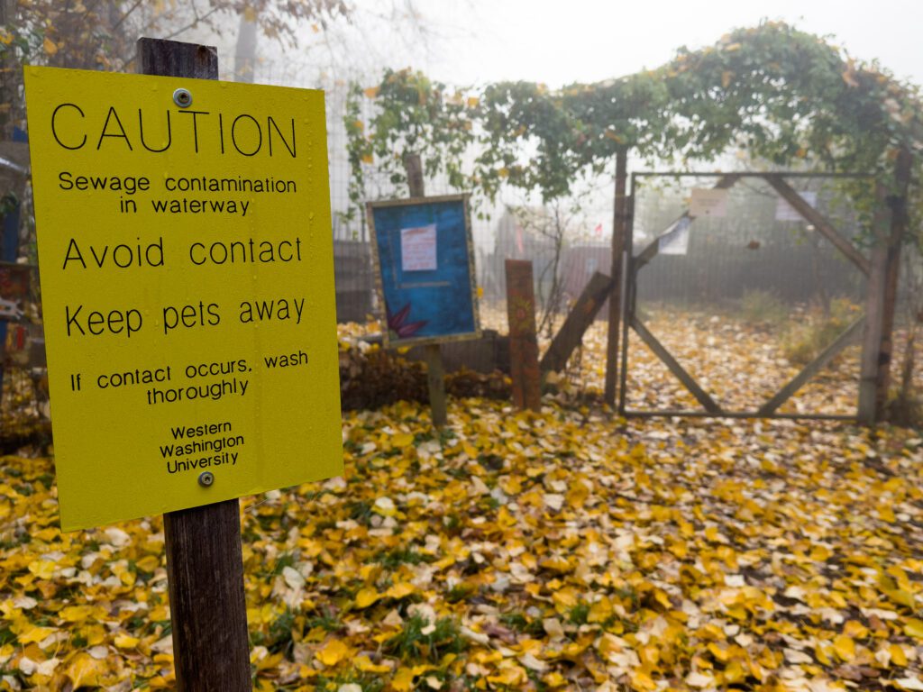 A bright yellow sign posted at the main entrance to the Outback Farm warns of a sewage leak.