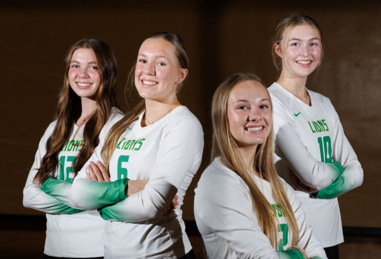 Lynden volleyball's four seniors, from left, Haylee Koetje, Grace Rice, Mya VanderYacht and Ashley Shumate pose for a photo with their arms crossed and wearing their team's signature jersey.