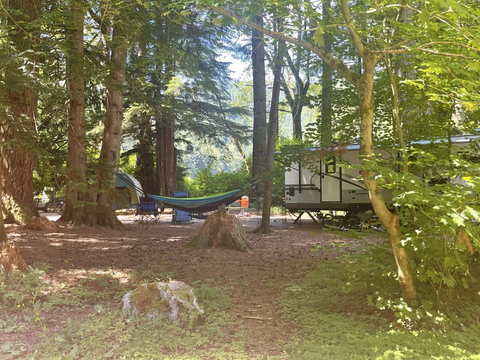 The Maple Creek Campground at Silver Lake Park has a trailer parked near a hammock.