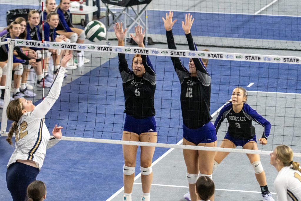 Nooksack Valley's Cailyn Likkel (5) and Elizabeth De Lange (12) raise their arms