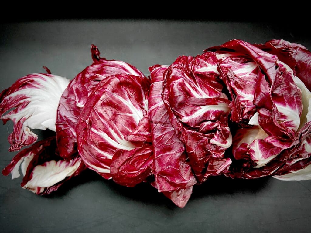 Cut red cabbages on a black plate.