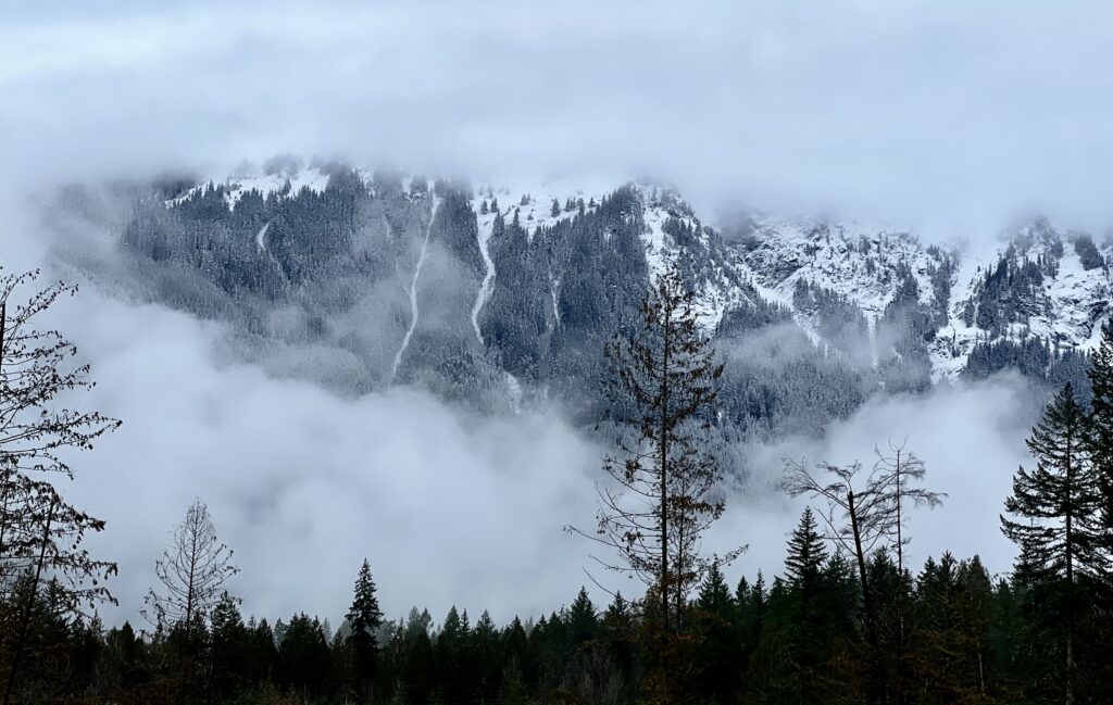 The North Cascades above the Nooksack River covered in snow and fog reducing the visibility of the mountain.