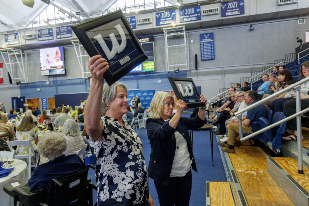 Laura Healy and Joane Larson Ischer stop for a photo and hold up their varsity letters from the school during an awards ceremony at Carver Gymnasium on May 20, in Bellingham. The duo were two of nearly 200 former athletes and coaches from 1968-81 receive variety letters on Saturday.