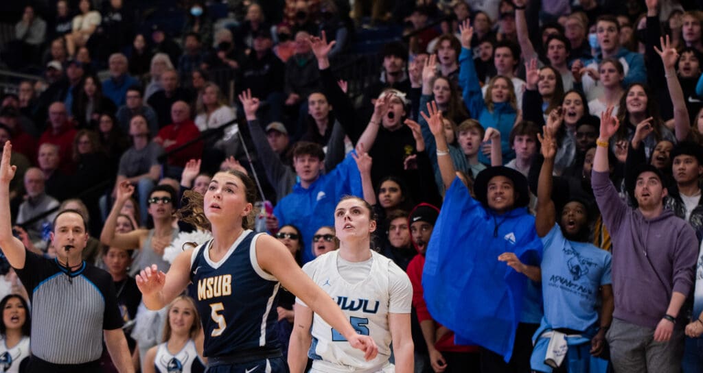 Western fans react as sophomore Maddy Grandbois watches her 3-pointer drop into the basket March 4 during the GNAC Championship game against Montana State University Billings.