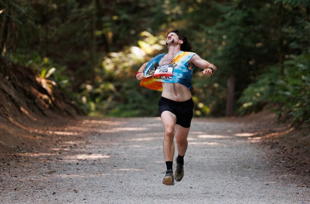 A runner tears at his shirt as he runs down the Lake Padden trail during the Bellingham Traverse.
