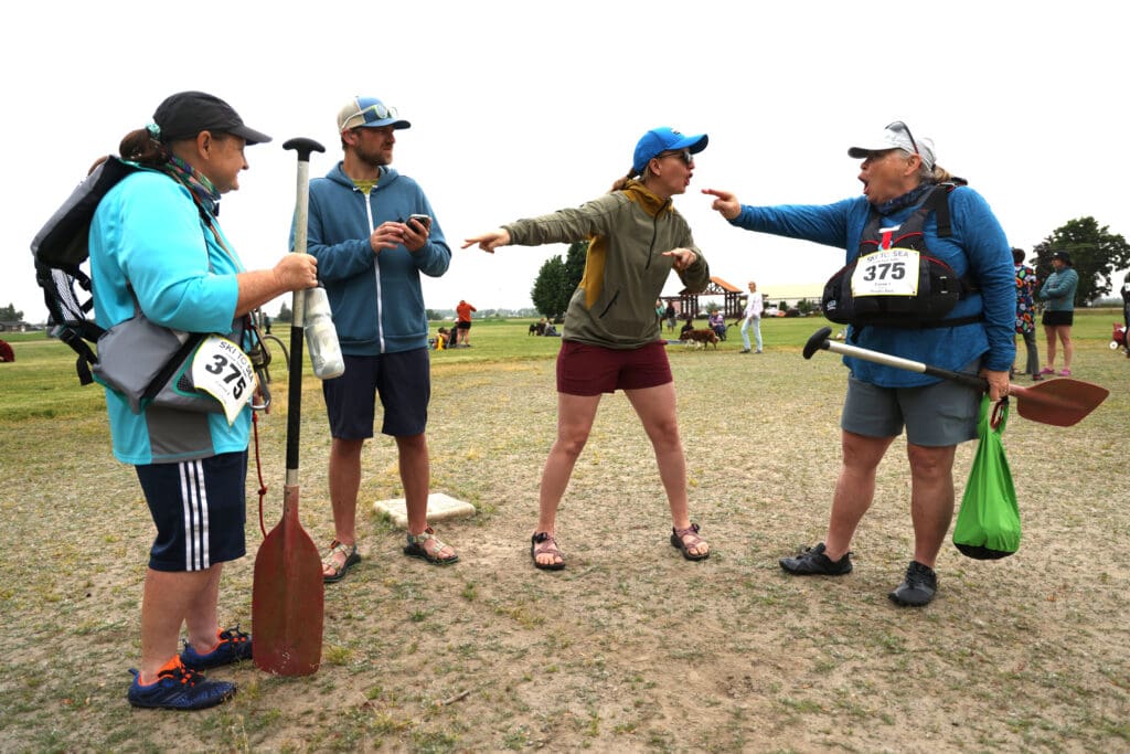 Miram Richards, Nic Yopp, Cara Frank and Darcie Lemieux use sign language as they chat before the canoe race of the 2023 Ski To Sea Race.