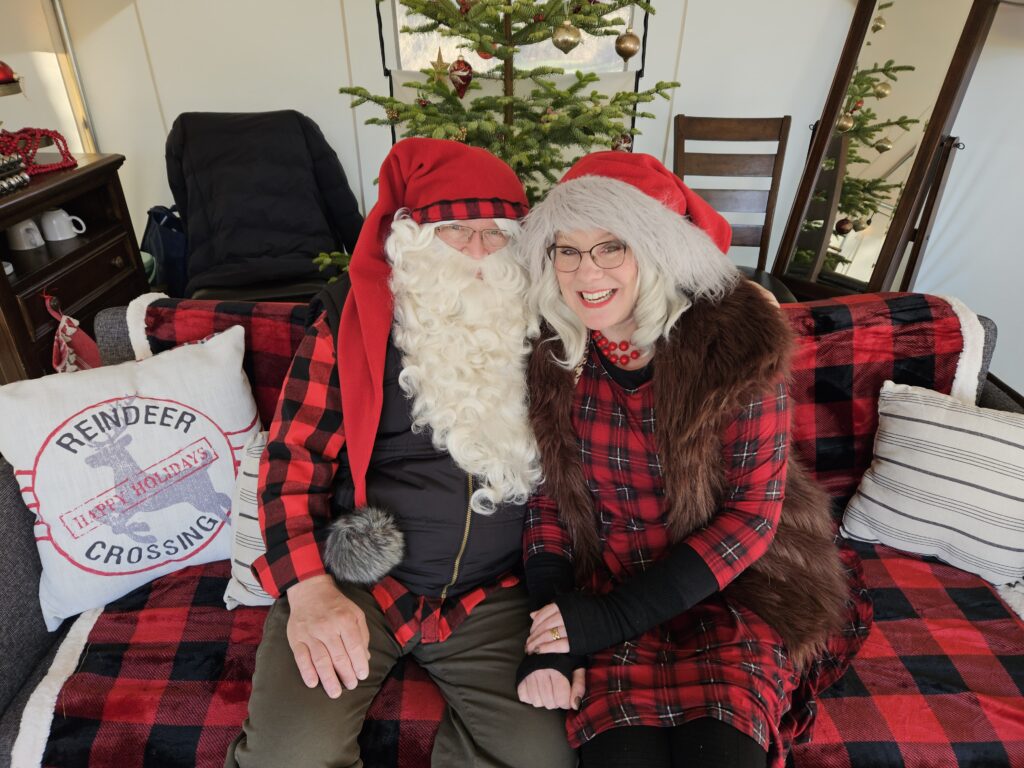 Peter, left and Shannon Day portraying Santa and "Missus" Claus sit on a flannel sofa.