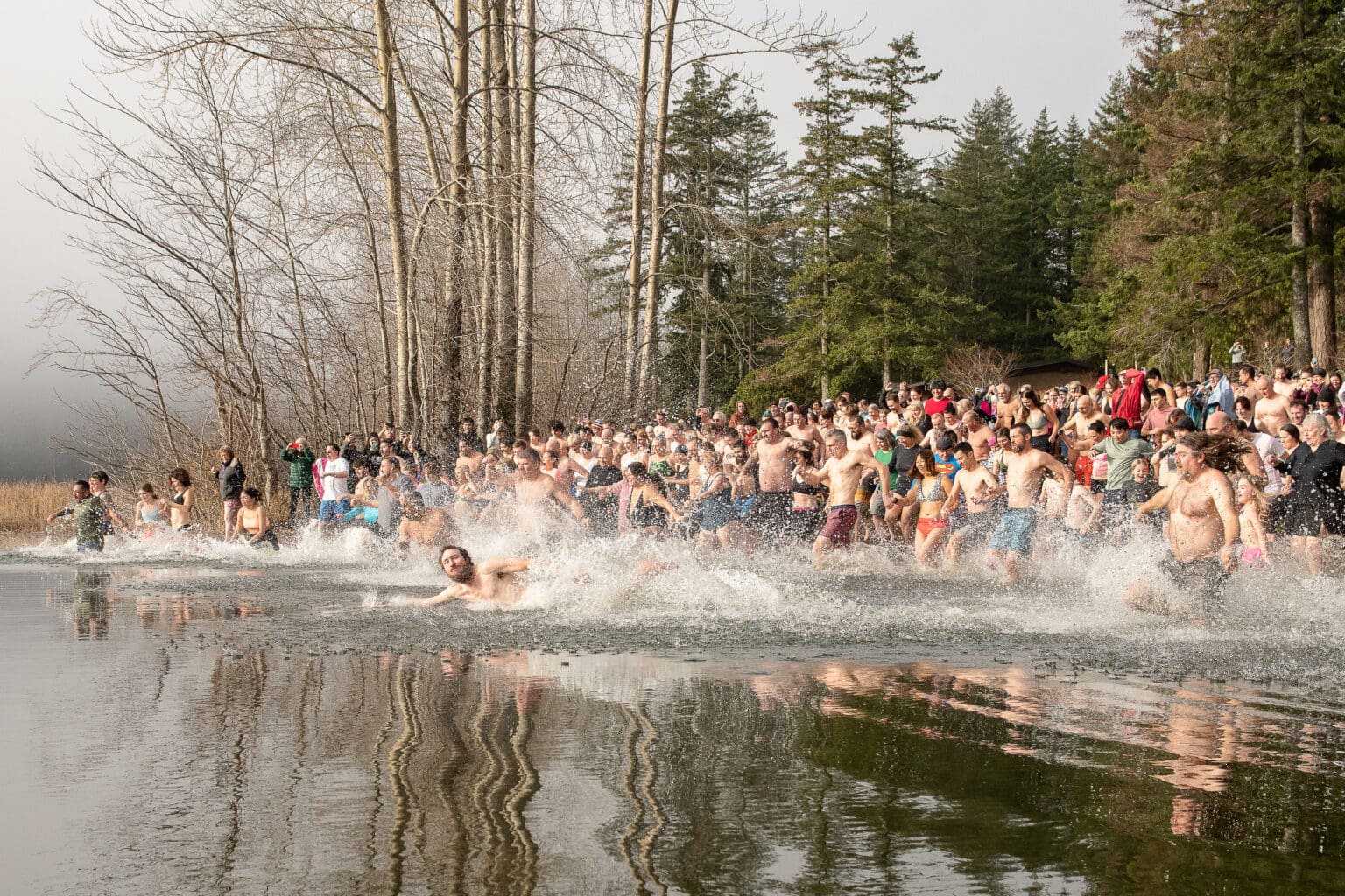 Crowds of Padden Polar Dip participants dash into the cold water as many wait their turn.