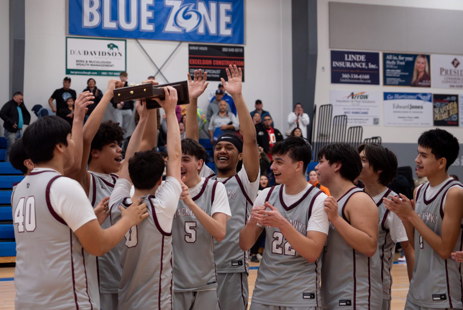The Lummi Nation Blackhawks lift the 1B Tri-District championship trophy Saturday, Feb. 17 after beating Neah Bay 53-47 at Mount Vernon Christian School.