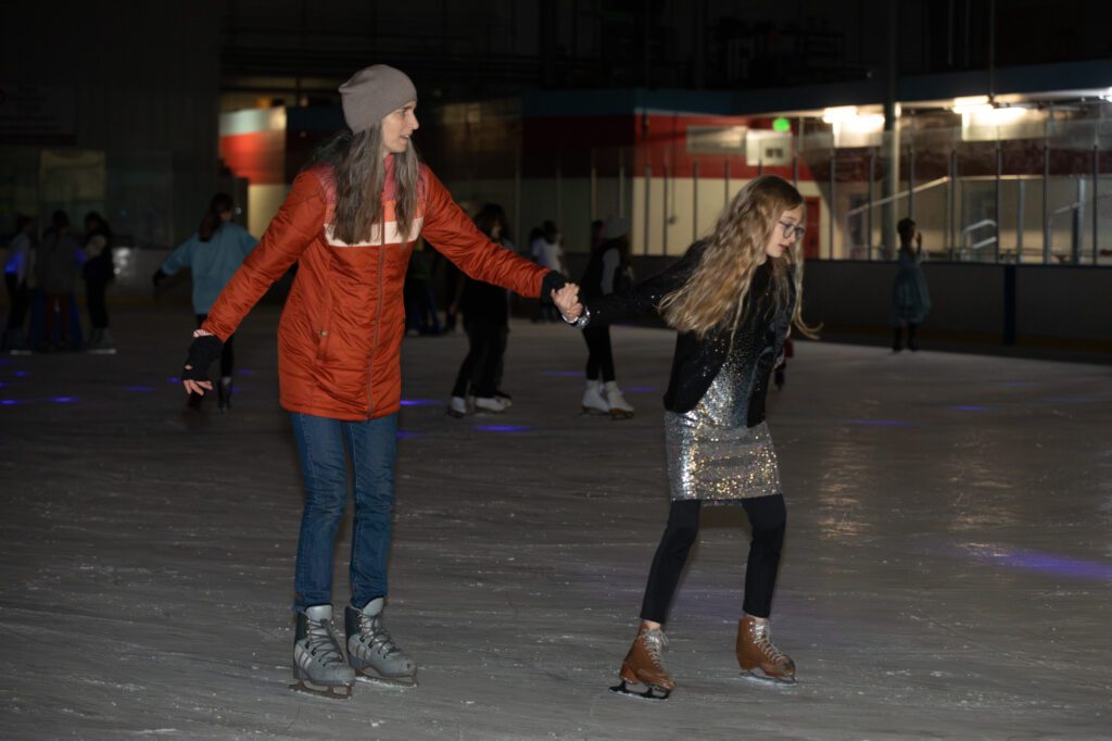 Serina Adams, left, and Piper Hope complete another lap around the rink near the end of the T-Swifty Skate event.